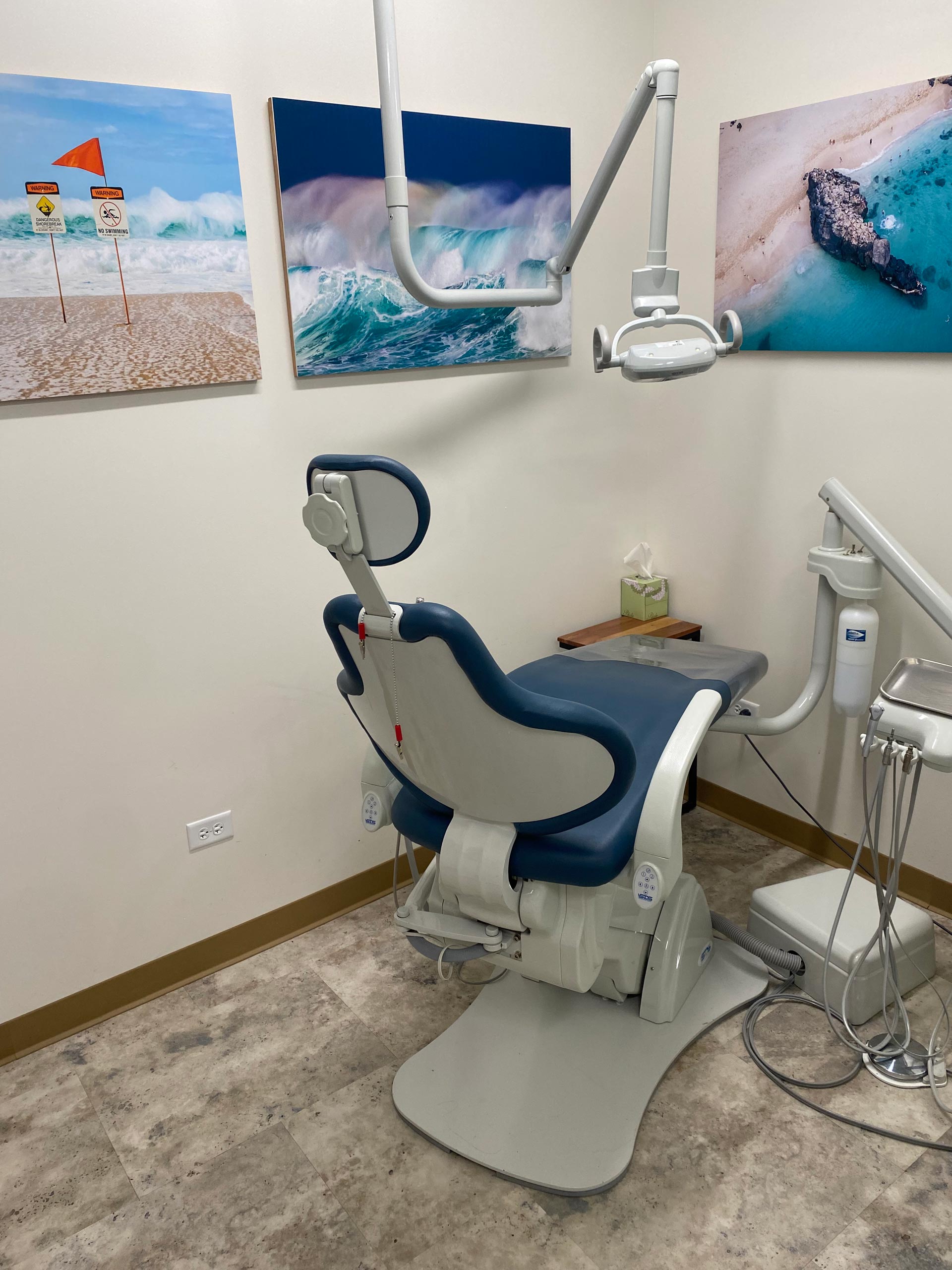 The image shows a dental office setup with a chair, adjustable light, and various pieces of equipment, including a dental chair, lamp, and possibly other tools for dental procedures.