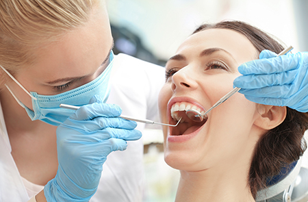 A dental hygienist performing teeth cleaning on a patient.